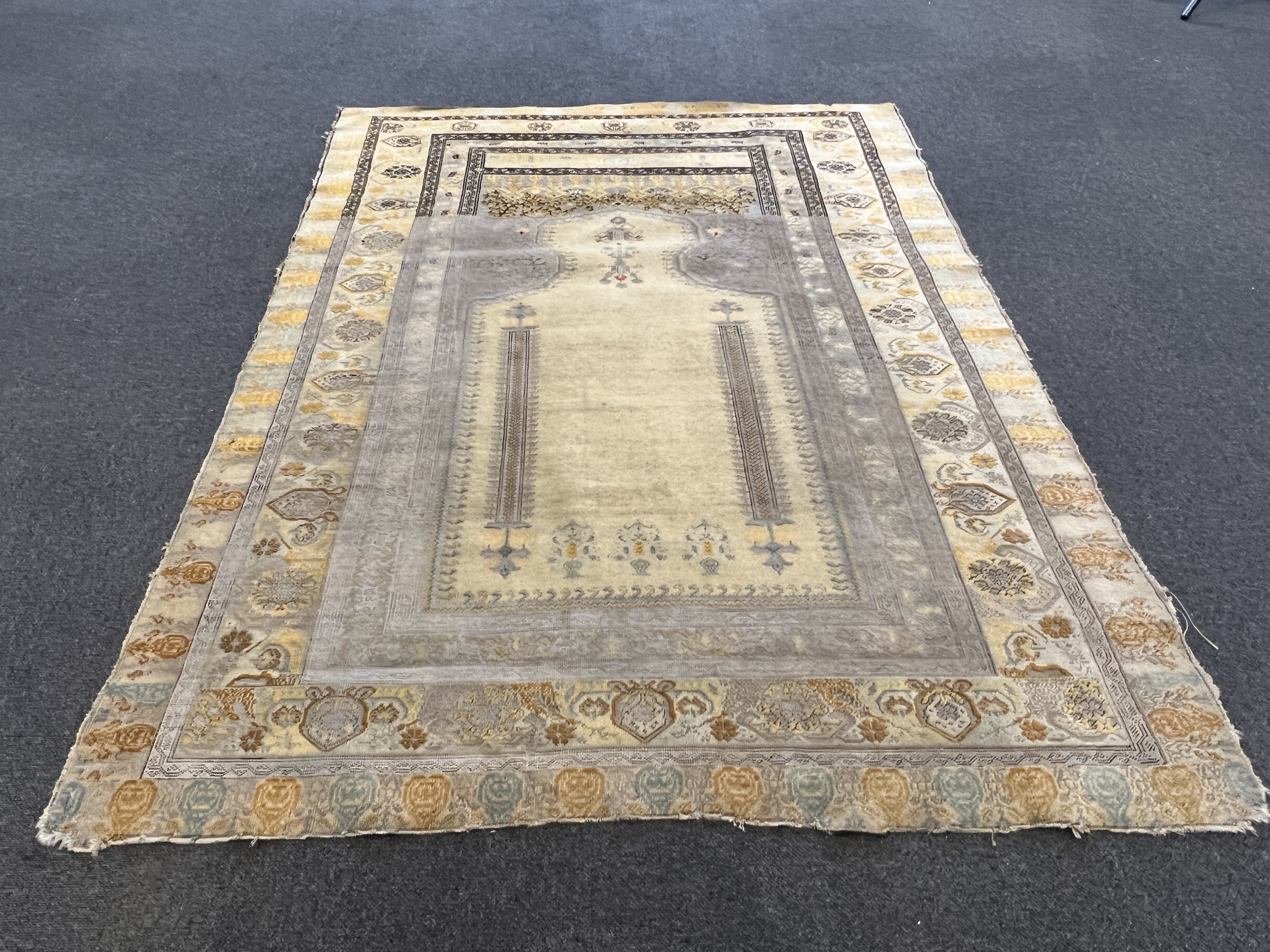 A Turkish silk prayer rug, with mihrab and stylised foliate borders on a gold ground, 185 x 137cm. Condition - the central panel severely worn to the tip of the mirror, lower fringe worn with losses.